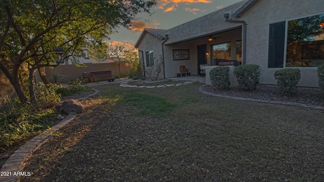 yard at dusk featuring a patio area