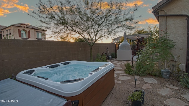 yard at dusk featuring a hot tub