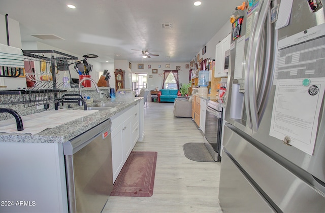 kitchen with ceiling fan, sink, light hardwood / wood-style flooring, white cabinetry, and stainless steel appliances