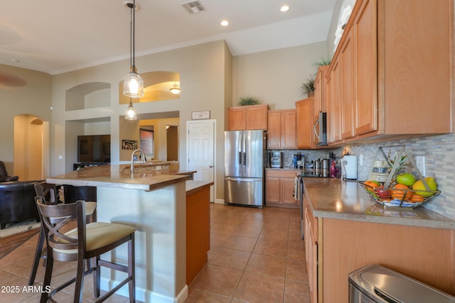 kitchen featuring visible vents, open floor plan, hanging light fixtures, stainless steel appliances, and light tile patterned flooring