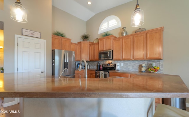 kitchen featuring tasteful backsplash, appliances with stainless steel finishes, a kitchen bar, high vaulted ceiling, and pendant lighting