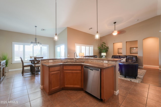 kitchen featuring open floor plan, stainless steel dishwasher, a sink, and a kitchen island with sink