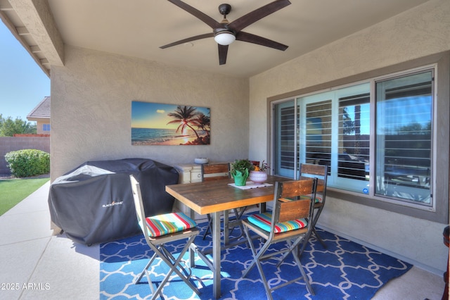 view of patio / terrace with grilling area, fence, outdoor dining area, and a ceiling fan