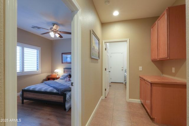 hallway with light tile patterned floors, baseboards, visible vents, and recessed lighting