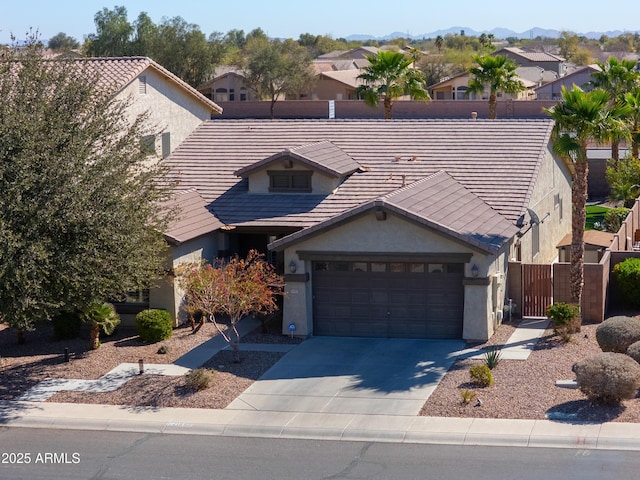 view of front of home with stucco siding, a residential view, concrete driveway, and a tiled roof