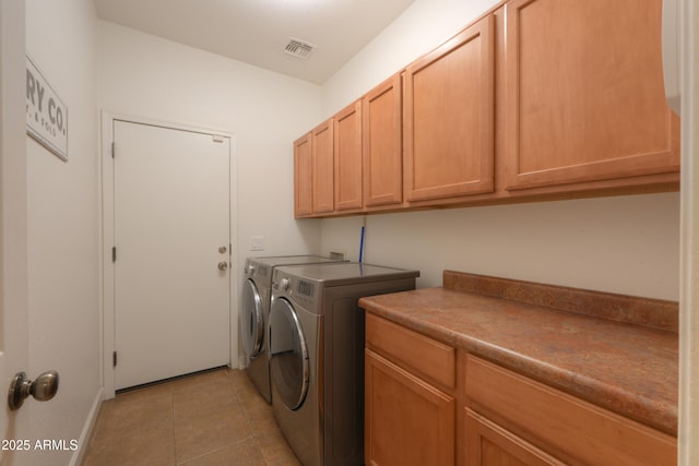 laundry area featuring cabinet space, light tile patterned floors, visible vents, and washer and clothes dryer