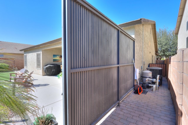 view of side of property featuring fence and a patio