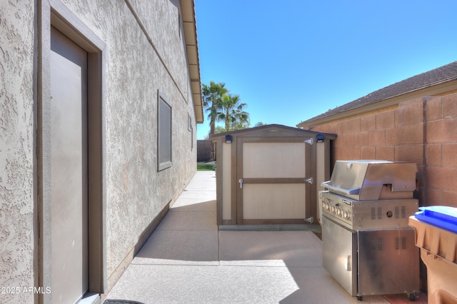 view of patio with fence, an outdoor structure, and a storage unit