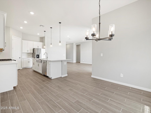 17561 W Pierson St, Goodyear, AZ 85395 - kitchen featuring open floor plan, stainless steel appliances, a chandelier, light wood-type flooring, and light countertops