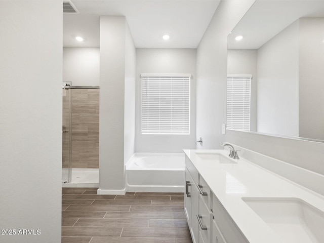 17561 W Pierson St, Goodyear, AZ 85395 - full bath with a garden tub, double vanity, wood tiled floors, a shower stall, and recessed lighting