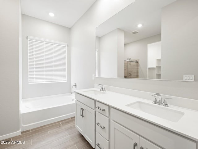 17561 W Pierson St, Goodyear, AZ 85395 - full bath featuring a bath, double vanity, wood finish floors, a shower, and recessed lighting
