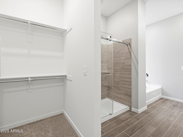 17561 W Pierson St, Goodyear, AZ 85395 - bathroom with a stall shower, a bath, wood finish floors, and baseboards