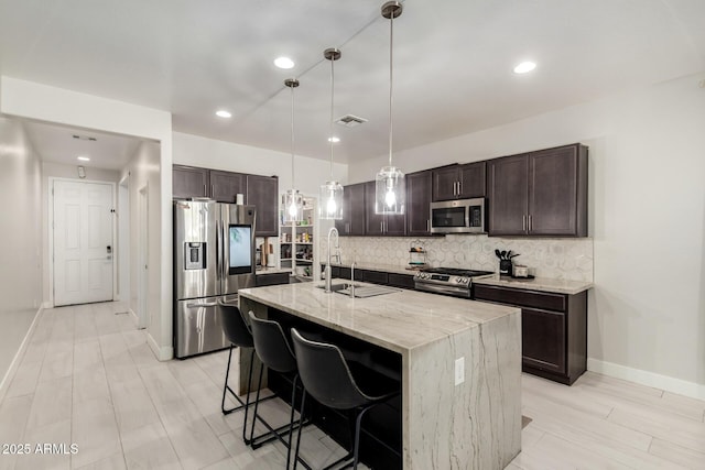 3715 S 57th Ln, Phoenix, AZ 85043 - kitchen featuring stainless steel appliances, dark brown cabinetry, decorative backsplash, light stone countertops, and recessed lighting