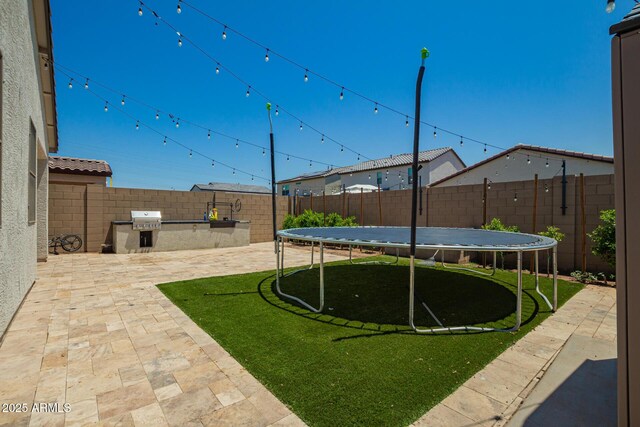 3715 S 57th Ln, Phoenix, AZ 85043 - fenced backyard featuring a trampoline and a patio area