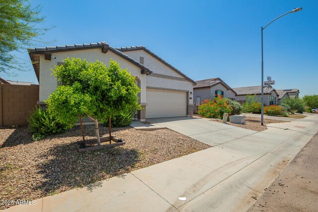 3715 S 57th Ln, Phoenix, AZ 85043 - view of front facade with concrete driveway, stucco siding, an attached garage, and a tiled roof