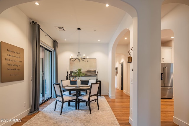 dining area featuring hardwood / wood-style floors and a notable chandelier