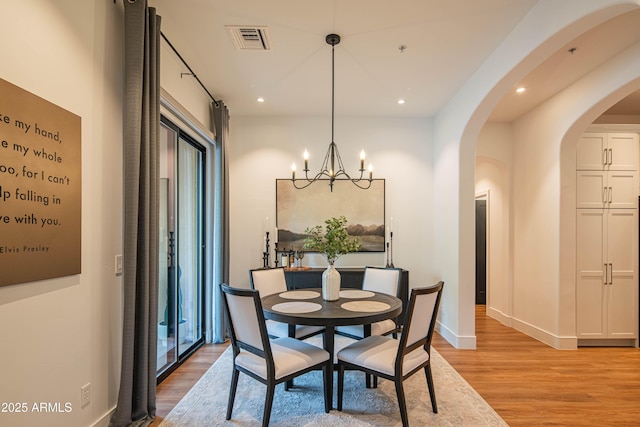 dining room featuring light hardwood / wood-style floors and a notable chandelier