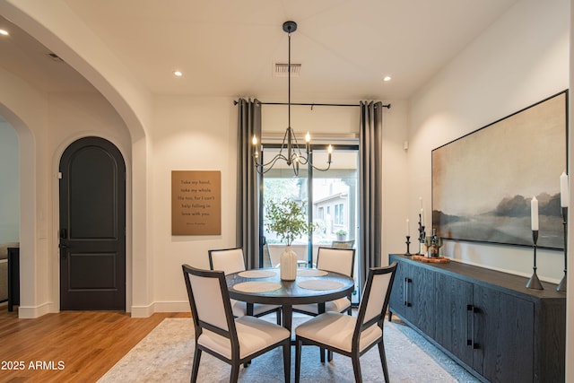 dining space with a chandelier and light hardwood / wood-style flooring