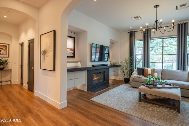 living room with an inviting chandelier and light hardwood / wood-style flooring