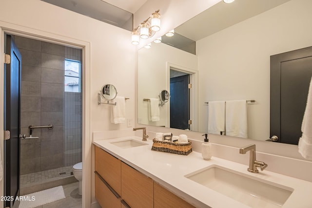 bathroom with toilet, vanity, and a tile shower