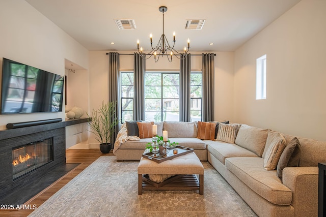 living room with a chandelier, a healthy amount of sunlight, and hardwood / wood-style floors