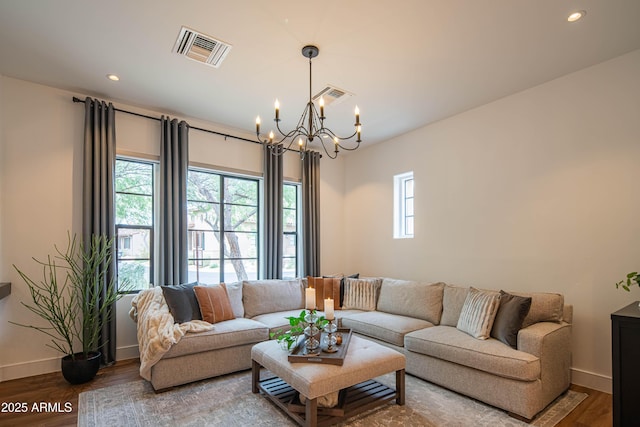 living room with plenty of natural light, an inviting chandelier, and hardwood / wood-style floors