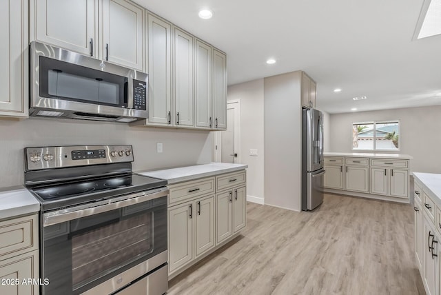 kitchen featuring light hardwood / wood-style floors, stainless steel appliances, and cream cabinetry