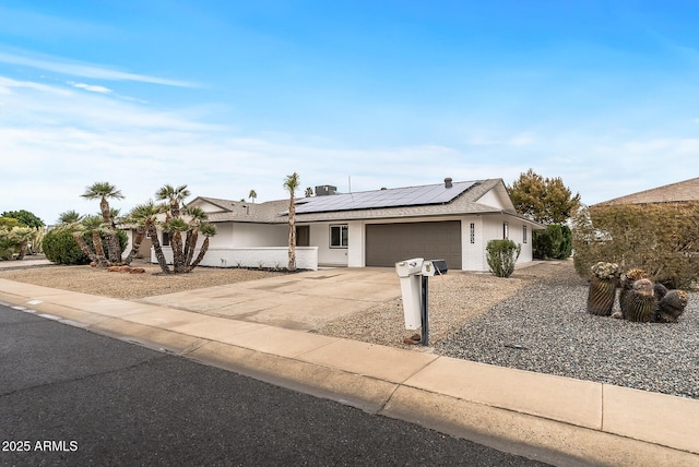 single story home featuring a garage and solar panels