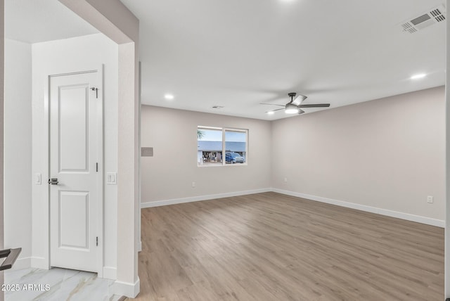 empty room with ceiling fan and light hardwood / wood-style floors