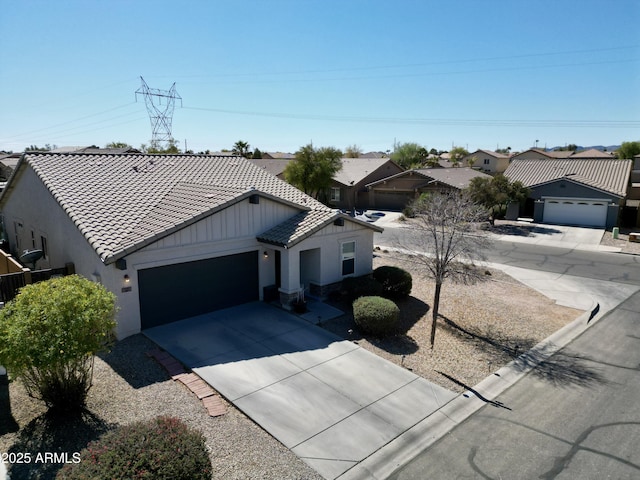 view of front of home with stucco siding, concrete driveway, a garage, a residential view, and a tiled roof