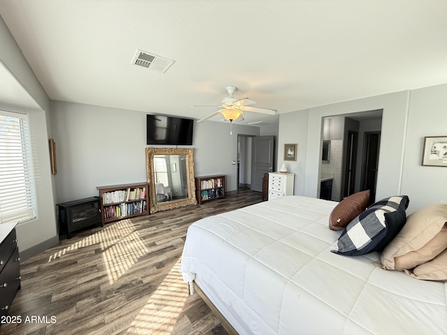 bedroom featuring a large fireplace, wood finished floors, and visible vents