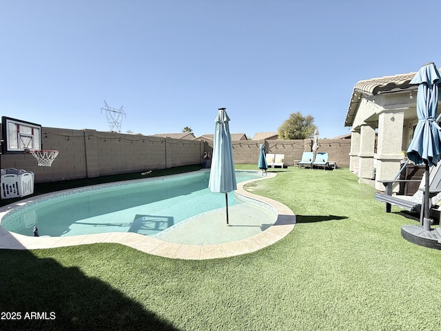 view of swimming pool featuring a fenced backyard and a lawn