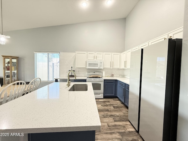 kitchen with hanging light fixtures, white cabinetry, a sink, blue cabinets, and white appliances