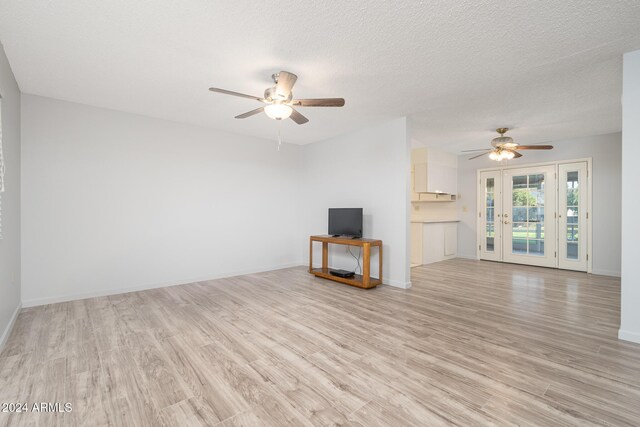 unfurnished living room with ceiling fan, light hardwood / wood-style flooring, and french doors