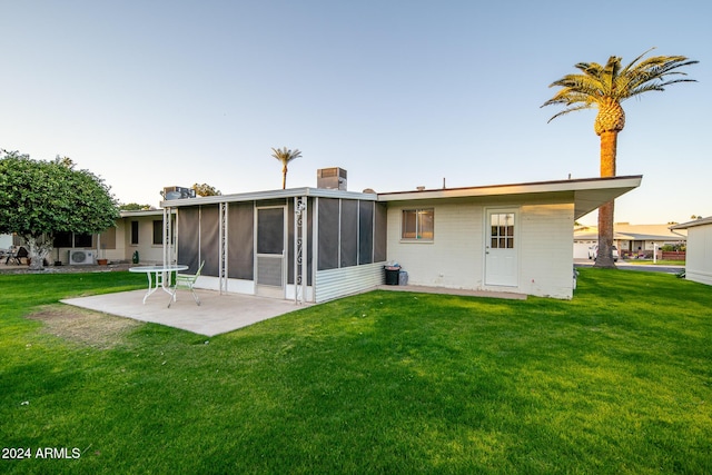 rear view of property with a sunroom, a patio area, and a yard