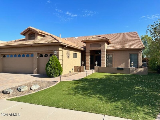 mediterranean / spanish house with a front yard and a garage