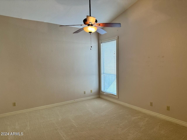 carpeted spare room featuring ceiling fan and lofted ceiling