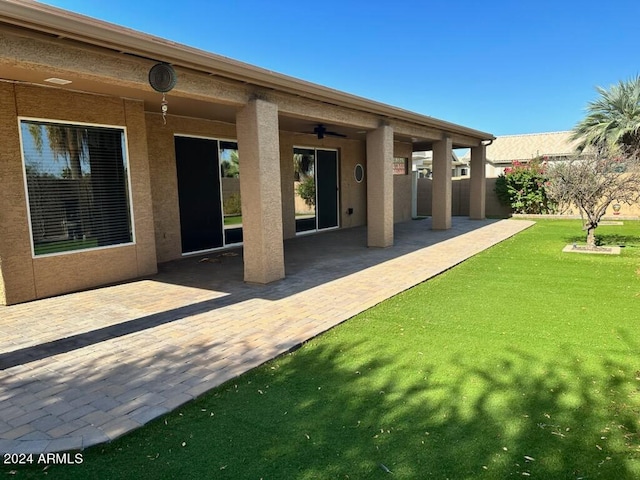 back of house featuring a patio, ceiling fan, and a lawn