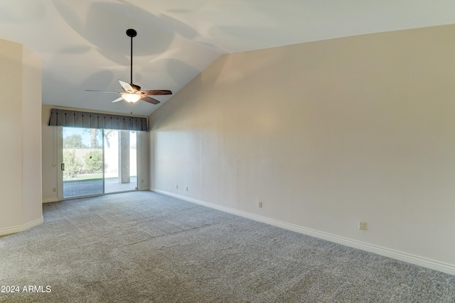 empty room featuring ceiling fan, vaulted ceiling, and light colored carpet