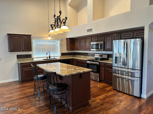 kitchen featuring a center island, stainless steel appliances, sink, and dark hardwood / wood-style flooring