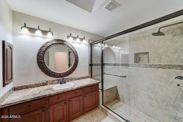 bathroom with a shower with door and vanity