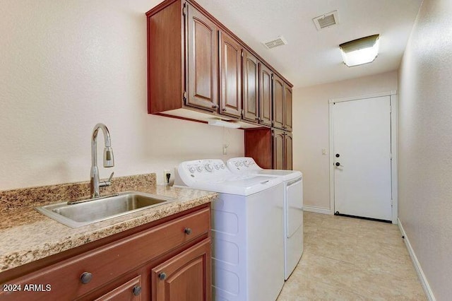 washroom with washing machine and dryer, sink, and cabinets