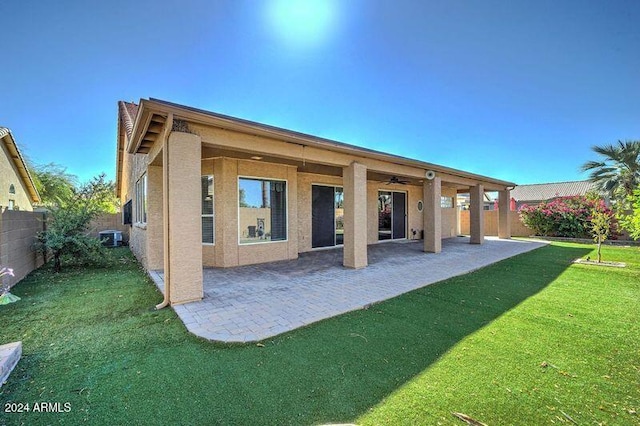 back of house with cooling unit, a patio, a lawn, and ceiling fan