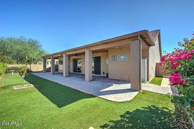 back of house with a patio area, a lawn, and ceiling fan