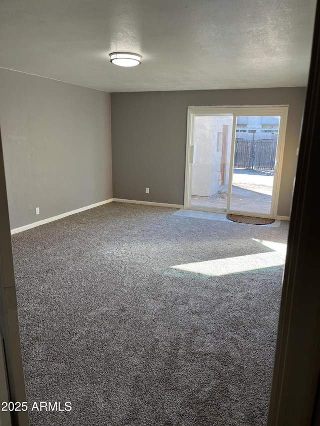 carpeted empty room featuring a textured ceiling