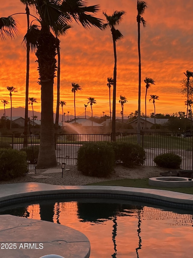 view of pool at dusk