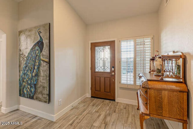 foyer featuring vaulted ceiling and light hardwood / wood-style floors