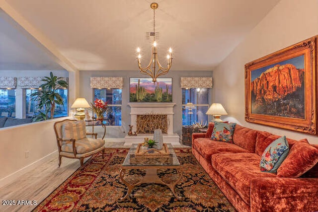 living room featuring lofted ceiling, light hardwood / wood-style floors, and a chandelier