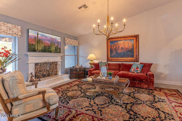 living room featuring hardwood / wood-style floors, an inviting chandelier, and a high end fireplace