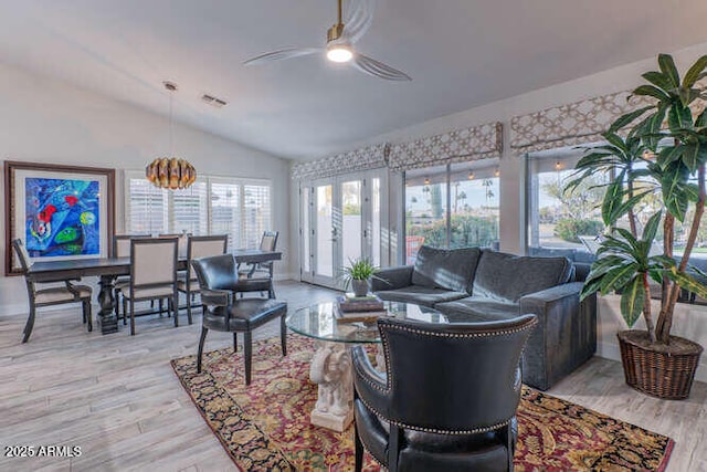 living room featuring light hardwood / wood-style flooring, vaulted ceiling, and ceiling fan